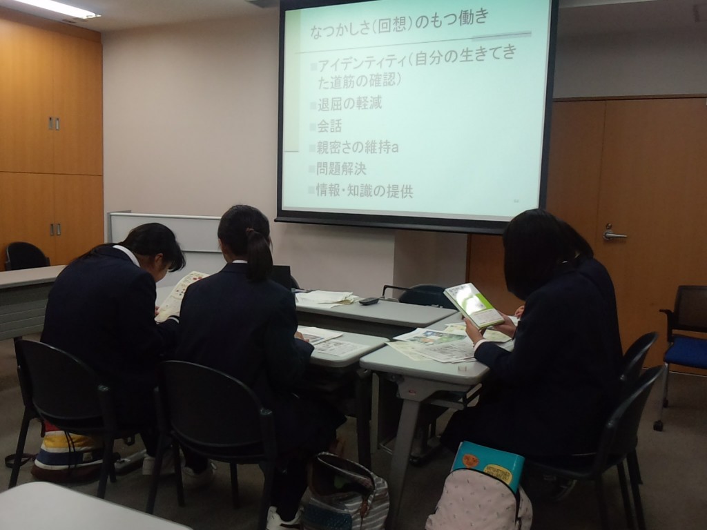 実験室において,記憶研究資料を見る高校生
